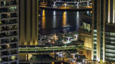 Dubai Yat Limanı mesire ve kanal kayan yat ve tekne Dubai, Birleşik Arap Emirlikleri ile gece timelapse güzel hava en iyi manzaraya. Yanıp sönen ışıklar ve yolda trafik ile ışıklı modern kuleleri. 