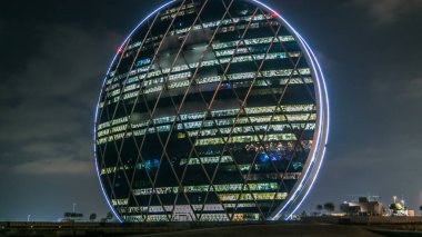 Abu Dhabi, Birleşik Arap Emirlikleri - Ocak 2017 yaklaşık: Abu Dhabi, Birleşik Arap Emirlikleri Orta doğuda kendi türünde ilk dairesel yapının gece timelapse bina Aldar güvenliğinizin komuta merkezidir. Bulutlu gökyüzü
