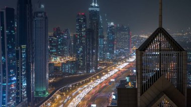 Modern gökdelenler ve meşgul akşam Karayolları gece timelapse lüks Downtown Dubai şehrinin görüntüleyin. Kule çatı üst hava manzara. Dubai, Birleşik Arap Emirlikleri
