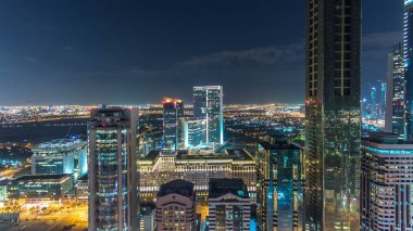 Doğal Dubai şehir mimarisi gece timelapse. Hava üstten görünüm ışıklandırılmış gökdelenler ve trafik ile Şeyh Zayed Yolu üzerinde. Uzun boylu kuleleri ve bulutlu gökyüzü