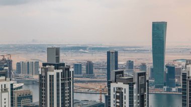 Dubai'nin iş bay önce günbatımı timelapse kuleleri. Çatı görünümü bazı gökdelenler ve yapım aşamasında yeni kuleleri. Bulutlu gökyüzü
