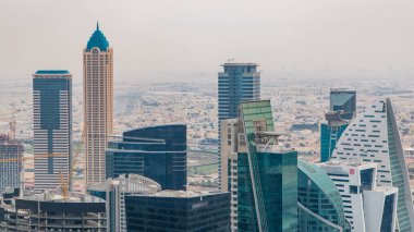 Dubai'nin iş bay önce günbatımı timelapse kuleleri. Çatı görünümü bazı gökdelenler ve yapım aşamasında yeni kuleleri. Bulutlu gökyüzü