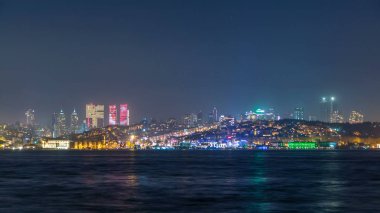 Gece timelapse görünümü ile bazı gökdelenler şehrin Asya bölümünden alınan istanbul'daki Beşiktaş bölgesinin. Boğaz'ın su yansıması
