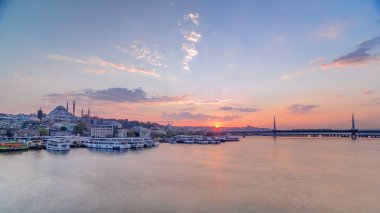 Günbatımı timelapse, Istanbul manzarası, Türkiye'de Haliç yakınındaki Boğaz'ın tekne istasyonu yakınındaki yolcu feribot. Cami ve arka plan üzerinde köprü ile sping gün su yansıma