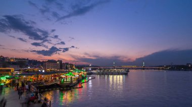 Yolcu Haliç yakınındaki Boğaz tekne station civarındaki için gece geçiş timelapse, Istanbul manzarası, Türkiye gün batımı gün sonra feribot. Cami ve arka plan üzerinde köprü ile sping gün su yansıma