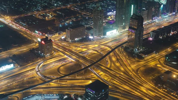 Aerial view of highway junction at night in Dubai, UAE. View from the height of Burj Khalifa timelapse 4K