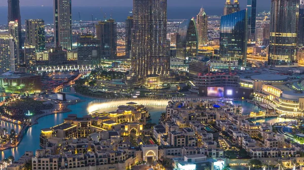 Dubai Downtown gün gece geçiş timelapse müzik çeşme gösterisi Uluslararası Dubai Kongre ve Sergi Sarayı yakınında ile otomasyon ve diğer yeni yıl kutlama Dubai, Suudi Arabistan içinde önce üstten görünüm kadar kapatın. Işıkları açma.