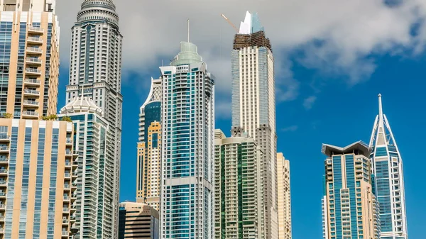 Luxurious Residence towers Buildings timelapse in Dubai Marina, UAE. Close up view with blue cloudy sky