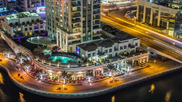 Dubai Yat Limanı mesire restoran ve kanal kayan yat ve tekne Dubai, Birleşik Arap Emirlikleri ile gece timelapse güzel hava en iyi manzaraya. Yanıp sönen ışıklar ve yolda trafik ile ışıklı modern kuleleri. 