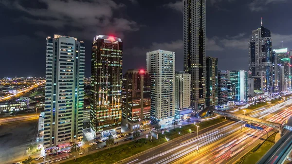 迪拜市中心的塔楼夜间经过 有摩天大楼的谢赫扎耶德公路的空中景观 公路和地铁的交通 闪烁的灯光和小径 — 图库照片