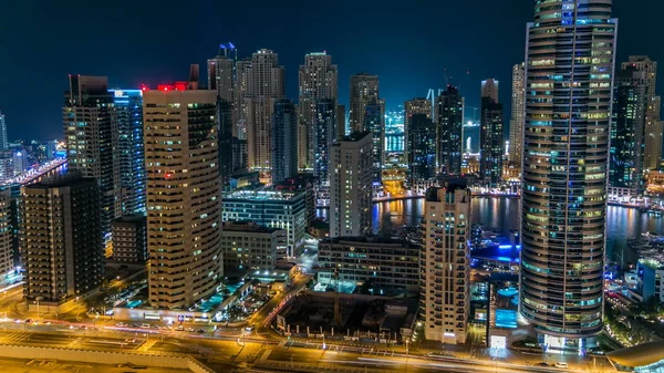 美丽的空中俯视图 在晚上游戏中时光倒流的迪拜码头长廊和运河与浮动的游艇和小船在迪拜 阿拉伯联合酋长国 照明现代塔与闪烁的灯光和公路的交通 — 图库照片