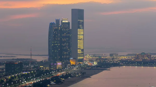 stock image Top view of famous towers buildings in Abu Dhabi day to night transition timelapse from rooftop. United Arab Emirates. Five towers complex with 74 floors is the third tallest building in Abu Dhabi.