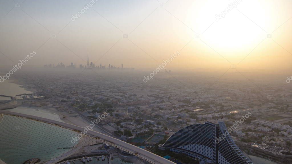 Skyline view of Dubai at the early morning after sunrise showing the Burj Khalifa and skyscrapers of Sheikh Zayed Road, Jumeirah beach and hotel with yacht in Dubai, UAE.  timelapse from burj al arab 4K 
