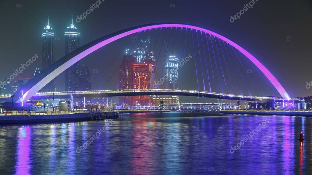 Puente peatonal iluminado sobre el timelapse nocturno del Canal de Agua