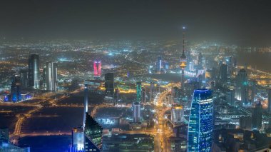 Manzarası ile gökdelenler gece timelapse Kuveyt City şehir merkezinde akşam aydınlatılmış. Kuveyt City, Orta Doğu. Çatıdan görüntülemek
