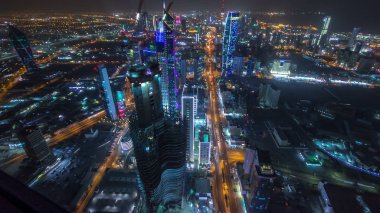 Manzarası ile gökdelenler gece timelapse Kuveyt City şehir merkezinde akşam aydınlatılmış. Kuveyt City, Orta Doğu. Sisli hava çatı üzerinden görüntülemek