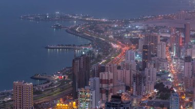 Manzarası ile gökdelenler gün gece geçiş timelapse Kuveyt City şehir merkezinde akşam aydınlatılmış için. Kuveyt City, Orta Doğu. Çatıdan görüntülemek