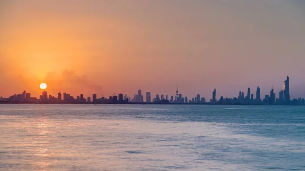 Top view of Kuwait cityscape during the sunset timelapse with modern skyscrapers reflected in water