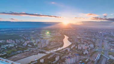Aerial top view of Moscow city timelapse at sunset. Form from the observation platform of the business center of Moscow City. Moscow river and traffic on roads at summer day clipart