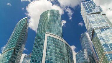 Moskova şehir timelapse cam yüzey üzerine düşünceler ile gökdelenler. İş ofisleri, Moskova, Rusya kurumsal binalar. Mavi bulutlu gökyüzü arka plan üzerinde.