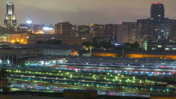 Evening top view of three railway stations night timelapse at the Komsomolskaya square in Moscow, Russia. Aerial view from rooftop. Trains on tracks.