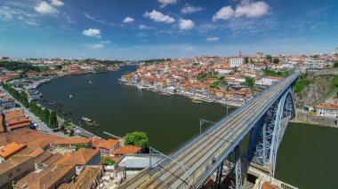 Porto, Portekiz Dom Luiz köprü timelapse mavi bulutlu gökyüzü ile ile tarihi şehrin kırmızı çatılar üzerinden görüntüleyin. Metro bir tren köprüde görülebilir
