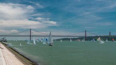 Almada ve Lizbon Portekiz timelapse bulutlu mavi gökyüzü 4 k geniş açı objektif bağlama April asma köprü arka plan üzerinde 25 ile Tagus Nehri üzerinde sailfishes