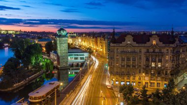 Sitkovska water-tower timelapse (circa 1588) and traffic on road in old city center of Prague day to night transition. World Heritage Site of UNESCO. View from top of dancing house clipart