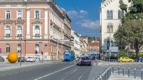 Street near new building of Croatian Music Academy timelapse in Zagreb, Croatia. Traffic on the road with trams, blue cloudy sky at sunny day