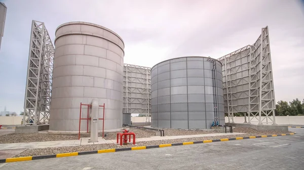 Two silver Water Tanks with fence timelapse. Cooling system. Cloudy sky