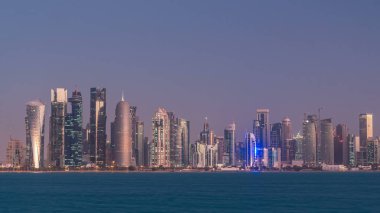 Arap şehri Doha 'nın ufuk çizgisi gece gündüz Katar' daki geçiş zamanı, gün doğumundan hemen önce aydınlık gökdelenlerle yakalandı. Corniche Gezinti Alanından Görünüm
