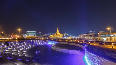 Souq Waqif Parkı 'ndaki küçük amfi tiyatro Doha' da gece vakti hızlandırılmış hiperhızlandırma, bitki örtüsü ve uzak mesafedeki binalar, aydınlatılmış İslam merkezi de dahil olmak üzere.