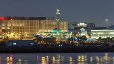 Al Shouyoukh Camii ve Saat Kulesi Katar 'ın başkenti Doha' da gece saatlerinde aydınlandı. Park manzarası. Orta Doğu
