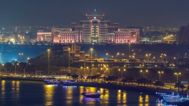Doha Ufuk Çizgisi İçişleri Bakanlığı ve Posta Ofisi gece çizelgesi. Yukarıdan hava görüntüsü. Körfez suyundaki yansıma. Doha, Katar, Orta Doğu