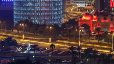 Doha Corniche ve kahve demliği anıtı. Havadan görünüşlü. Arka planda aydınlık gökdelenler ve yolda trafik