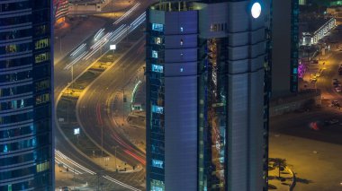 Katar, Doha Timelapse 'da West Bay yolunda trafik var. Aydınlatılmış modern gökdelenler ve gece çatıdan kesişen hava manzarası