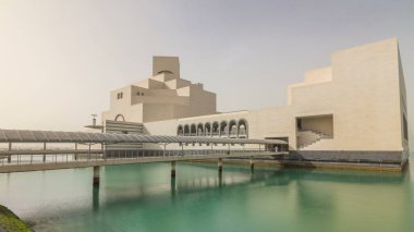 Doha, Katar - Jan 2018 yaklaşık: Katar'ın İslami Sanatlar Müzesi timelapse hyperlapse dhows onu çevreleyen koyda demirlemiş ile Doha Corniche, yanında insan yapımı, adada