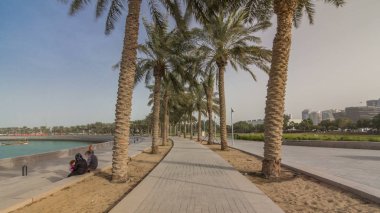 Yedi kilometre uzun Corniche başkentinde Katar, Doha, bir ucunda yer alan Mia Park timelapse yürümek. Palms yol her iki tarafında.
