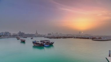 Geleneksel ahşap Dhow balıkçı tekneleriyle Doha Körfezi 'nde gün batımı. Corniche, Doha, Katar ile müzeden görüntü