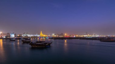 Geleneksel ahşap Dhow balıkçı tekneleriyle Doha Körfezi 'nde gece gündüz geçiş zamanı. Corniche, Doha, Katar ile müzeden görüntü