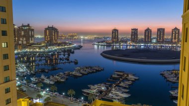 Pearl-Katar 'da akşamdan akşama, tepeden tırnağa. Katar 'da yapay bir ada. Doha, Katar, Orta Doğu 'daki Porto Arabistan' daki liman ve konut binalarının manzarası