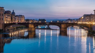 Ponte Santa Trinita 'nın (Kutsal Üçlü Köprü) alacakaranlık gökyüzü sahnesi gece gündüz Arno nehrinin üzerinde yansıyor, günbatımından sonra Ponte Santa Trinita - Florence, Tuscany, İtalya