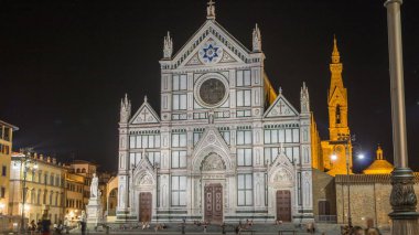 Santa Croce Meydanı 'ndaki turistler, Floransa' daki Bazilika di Santa Croce (Kutsal Haç Bazilikası) ile gece saatlerinde buluşuyorlar. Kilise ünlü İtalyanların gömüldüğü yerdir..