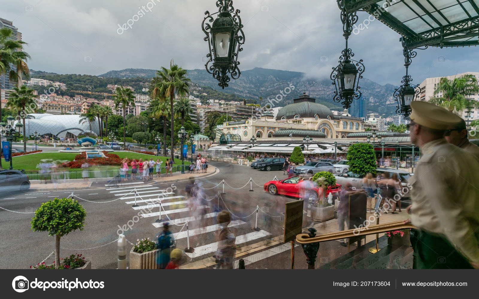 在摩纳哥蒙特卡洛游客们在昂贵的汽车和著名的赌场大楼附近拍照从赌场正门的楼梯往外看背景上有手掌的正方形——图库图片©