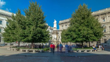 Leonardo da Vinci anıt Piazza della Scala (La Scala kare anlamına gelir) timelapse hyperlapse içinde. O Milan, İtalya'da 1872 yılında heykeltraş Pietro Magni tarafından tasarlanmış. Yaz günü mavi gökyüzü. Yeşil ağaçlar