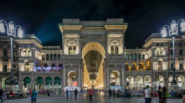 Gece görüş-in ışıklı Vittorio Emanuele II Galerisi timelapse Milan, İtalya. İnsanlar Meydanı Piazza Duomo girişine yakın.