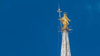 Milano, İtalya Milano Katedrali'ne timelapse üstüne Madonnina. Görünümü kapatın. Yaz günü bulutlu gökyüzü mavi. 1762 108.5 m yükseklikte bu heykeli dikildi.