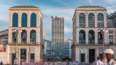 Piazza del Duomo Milan, İtalya, gökdelen ve Museo del Novecento timelapse dört bir yanındaki insanlarla görünümünü. Mavi bulutlu gökyüzü yaz gün batımına
