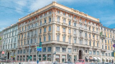 Güzel tarihi dönüm noktası - Palazzo Luraschi Porta Venezia timelapse (kavşak Avenue Buenos Aires ve sokak Bastioni di Porta Venezia) yakınındaki bir sokak görünümü. Milan, İtalya. Yolda trafik. Yaz günü, mavi gökyüzü