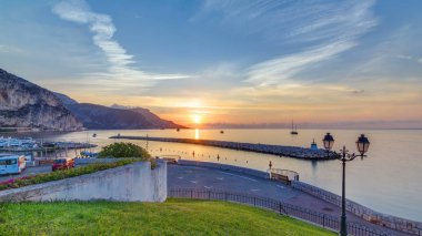 Beaulieu sur mer, Fransa 'dan deniz ve manzaranın gün doğumu görüntüsü. Tekneler ve yatlar ön planda. Sudaki yansımalar.